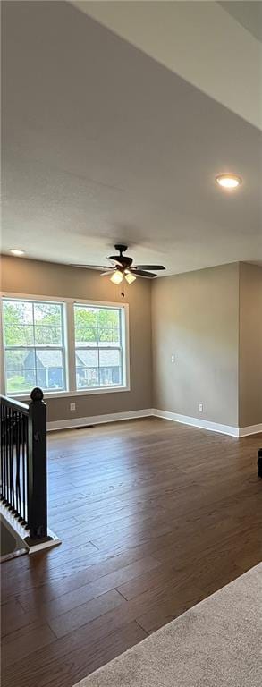 empty room featuring baseboards, hardwood / wood-style floors, and a ceiling fan