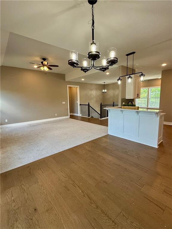 kitchen with decorative light fixtures, open floor plan, baseboards, and dark wood finished floors