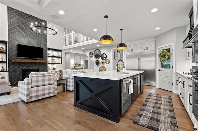 18050 N Peach Blossom Dr, Platte City, MO 64079 - kitchen featuring a sink, open floor plan, stainless steel appliances, light countertops, and an island with sink