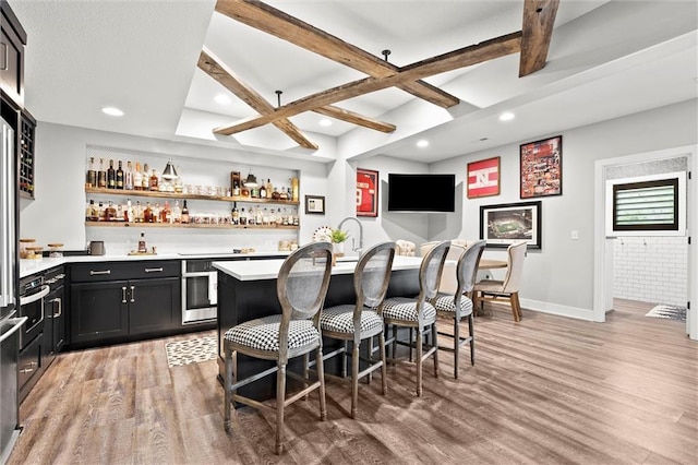 18050 N Peach Blossom Dr, Platte City, MO 64079 - indoor wet bar with light wood finished floors, coffered ceiling, beam ceiling, stainless steel oven, and baseboards