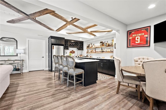 18050 N Peach Blossom Dr, Platte City, MO 64079 - kitchen with dark cabinetry, freestanding refrigerator, a breakfast bar area, a center island, and recessed lighting