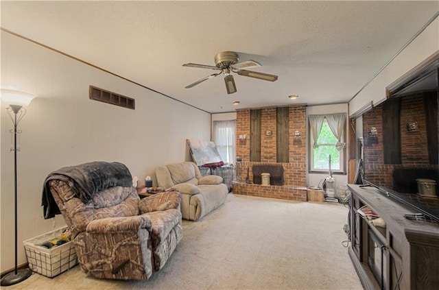 carpeted living room featuring a ceiling fan, a wood stove, a textured ceiling, and visible vents
