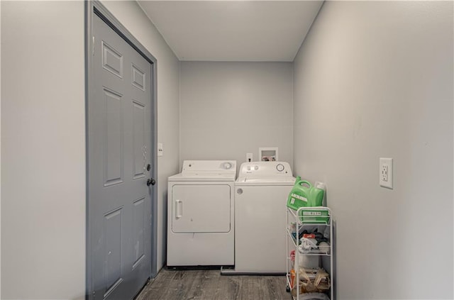 washroom featuring washing machine and dryer, dark wood-type flooring, and laundry area
