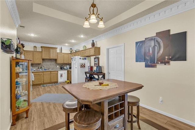 dining room featuring light wood-type flooring and baseboards
