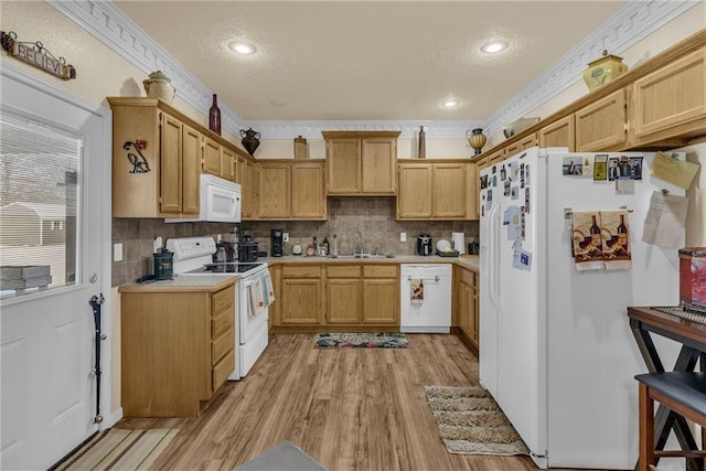 kitchen featuring white appliances, a sink, light wood-style floors, light countertops, and crown molding