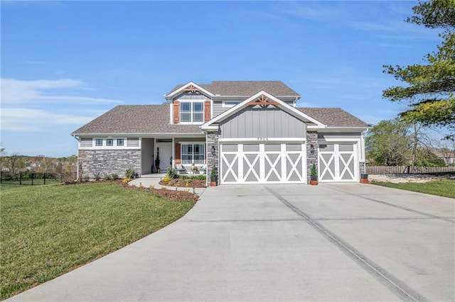 craftsman-style house featuring fence, a front lawn, board and batten siding, an attached garage, and driveway