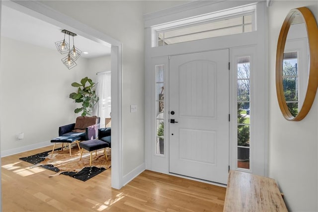 entrance foyer with baseboards, a wealth of natural light, and light wood-style floors