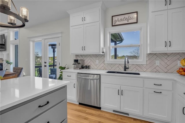 kitchen featuring light countertops, dishwasher, visible vents, and a sink