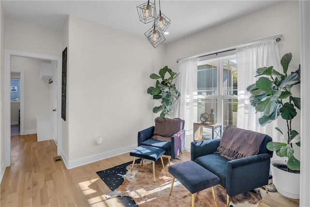 living area featuring baseboards and light wood-type flooring
