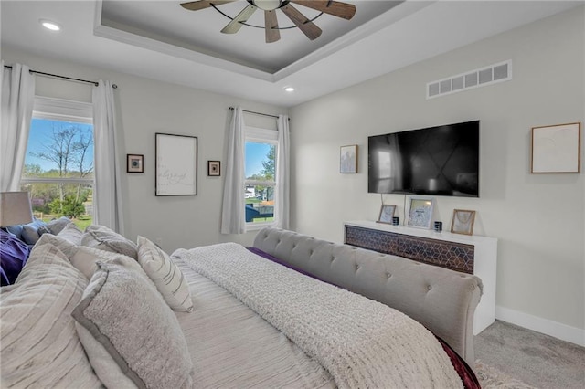 bedroom with carpet, visible vents, recessed lighting, and a raised ceiling