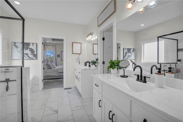 ensuite bathroom with two vanities, a sink, recessed lighting, marble finish floor, and connected bathroom