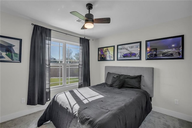 carpeted bedroom with visible vents, baseboards, and ceiling fan