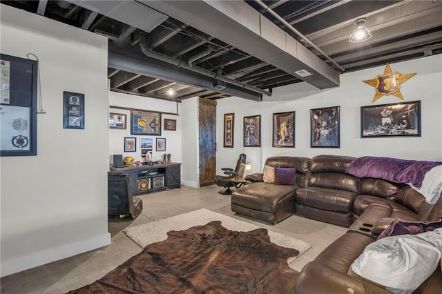 living area with baseboards and concrete flooring
