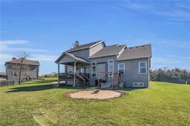 rear view of house with stairway, a yard, and a deck
