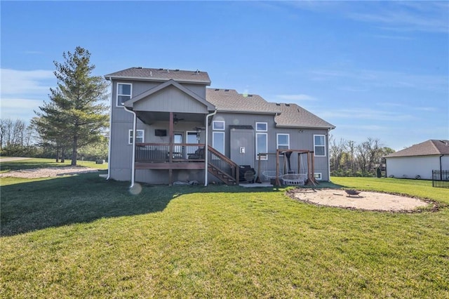 rear view of house with stairway, a deck, an outdoor fire pit, a yard, and ceiling fan
