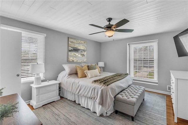 bedroom with wood ceiling, multiple windows, and wood finished floors
