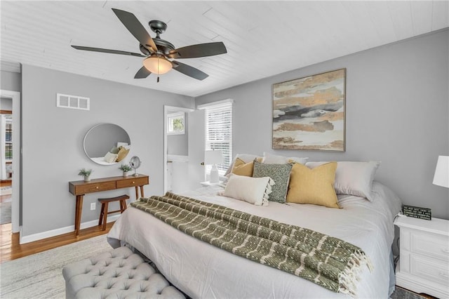 bedroom with ceiling fan, visible vents, wood finished floors, wooden ceiling, and baseboards