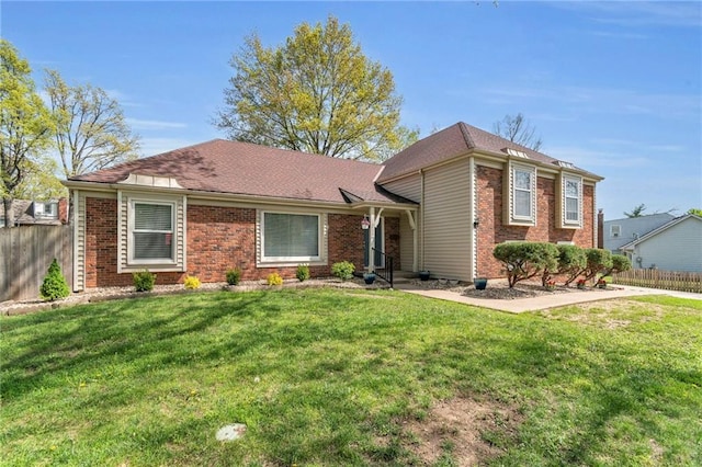 ranch-style home with brick siding, a front lawn, and fence