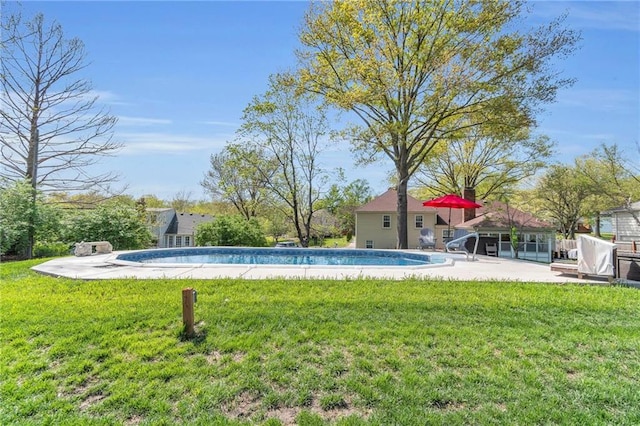 outdoor pool with a yard and a patio area