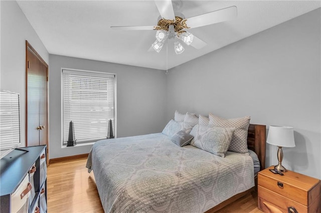 bedroom featuring baseboards, a ceiling fan, and light wood finished floors