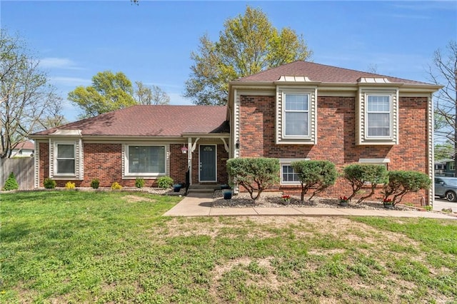 split level home featuring brick siding and a front yard
