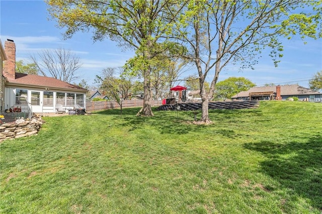 view of yard with fence and a sunroom