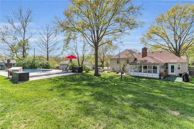 view of yard with a patio, an outdoor pool, and a sunroom