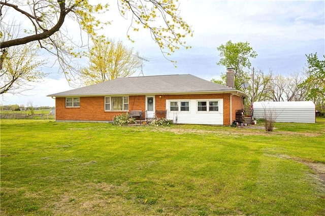 220 W John St, Milo, MO 64767 - view of front of house featuring brick siding, a chimney, fence, and a front lawn