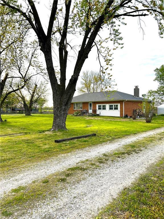 220 W John St, Milo, MO 64767 - single story home featuring a chimney, driveway, a front yard, and brick siding