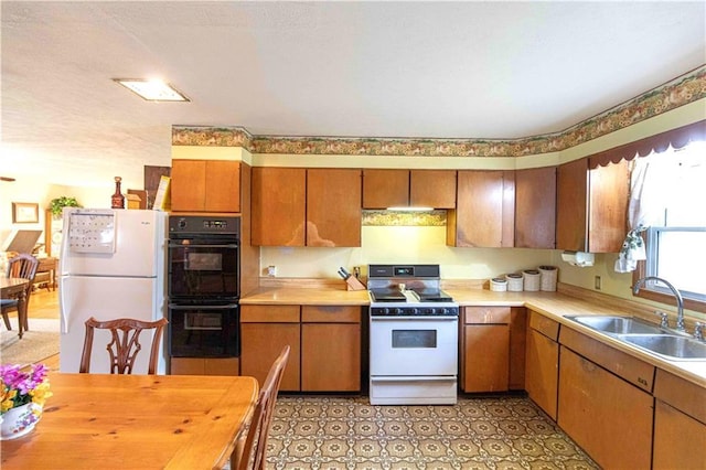 220 W John St, Milo, MO 64767 - kitchen featuring a sink, brown cabinetry, light countertops, and white appliances