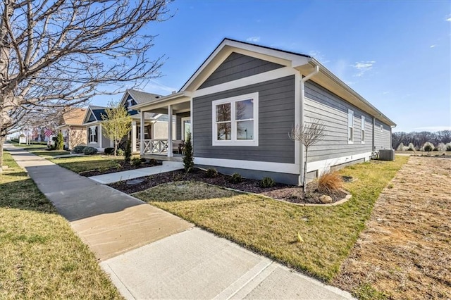 8137 N Farley Ave, Kansas City, MO 64158 - view of home's exterior featuring a lawn, covered porch, and central AC unit