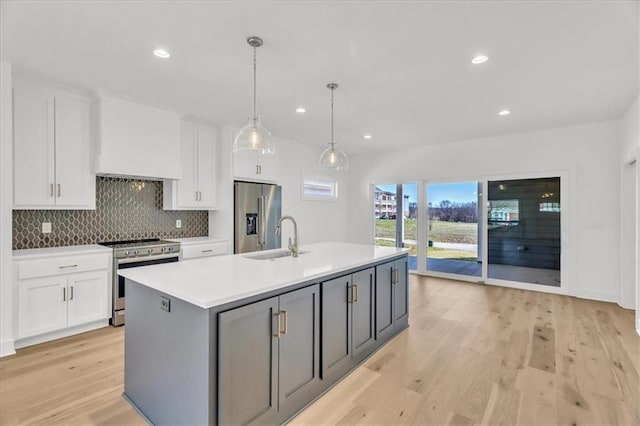 8137 N Farley Ave, Kansas City, MO 64158 - kitchen featuring light countertops, a sink, white cabinetry, appliances with stainless steel finishes, and light wood-type flooring