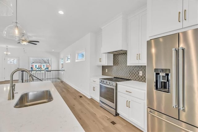 8137 N Farley Ave, Kansas City, MO 64158 - kitchen with a sink, a ceiling fan, white cabinetry, appliances with stainless steel finishes, and decorative backsplash