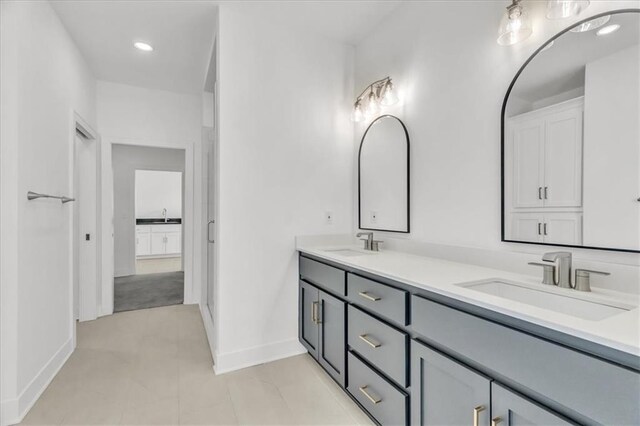 8137 N Farley Ave, Kansas City, MO 64158 - full bath featuring baseboards, double vanity, and a sink