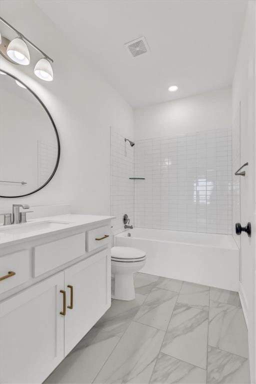 8137 N Farley Ave, Kansas City, MO 64158 - bathroom with toilet, vanity, marble finish floor, tub / shower combination, and visible vents