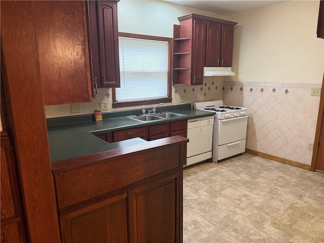 1014 S 12th St, Saint Joseph, MO 64503 - kitchen featuring a sink, white appliances, dark countertops, under cabinet range hood, and light flooring