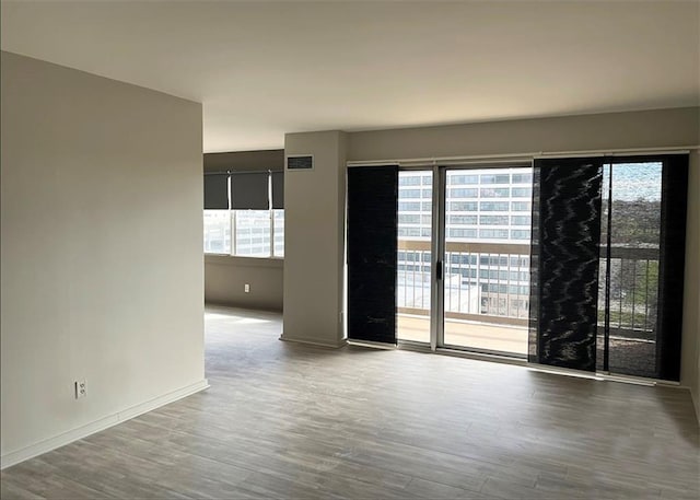 unfurnished room with visible vents, baseboards, and wood finished floors