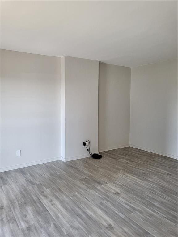 empty room featuring baseboards and wood finished floors