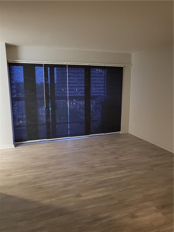 unfurnished room with wood finished floors and baseboards