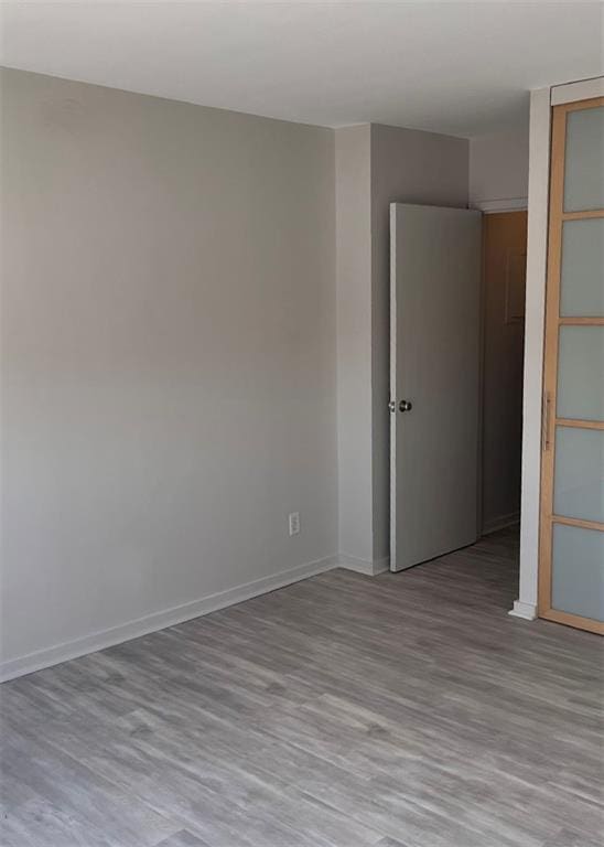 empty room featuring baseboards and wood finished floors