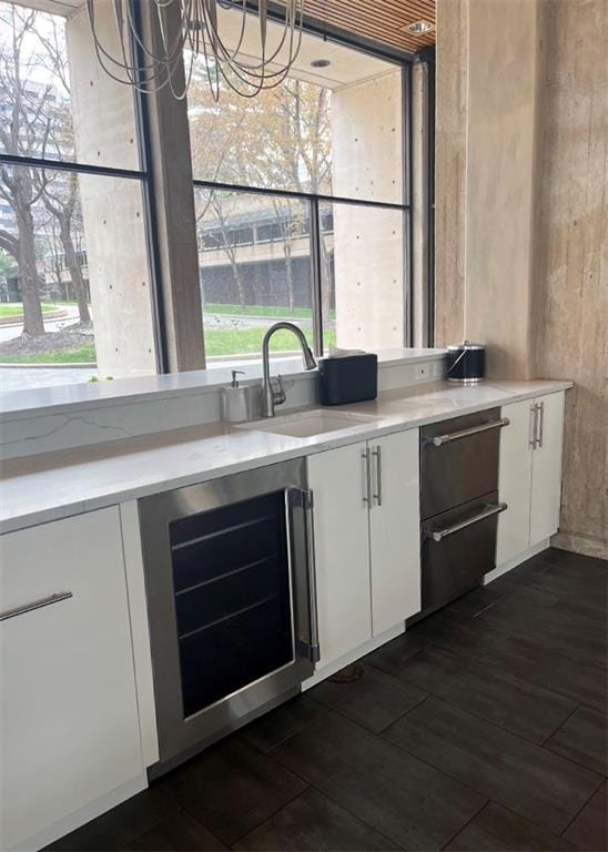 bar featuring dark wood-style flooring, a sink, and wine cooler