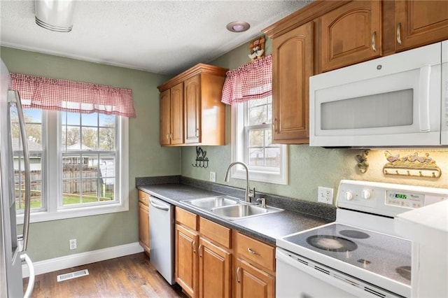 508 S 7th St, Louisburg, KS 66053 - kitchen featuring appliances with stainless steel finishes, a sink, wood finished floors, dark countertops, and brown cabinets