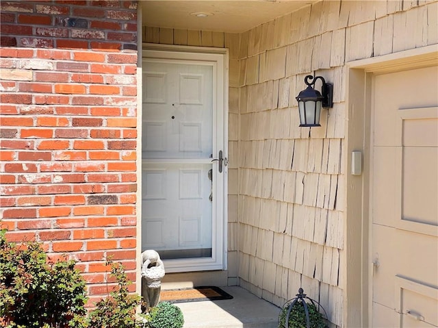 doorway to property featuring brick siding