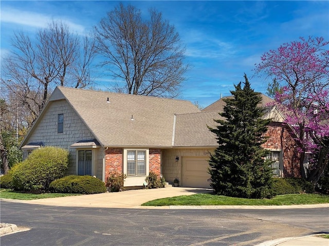 view of front facade with concrete driveway, brick siding, roof with shingles, and a garage