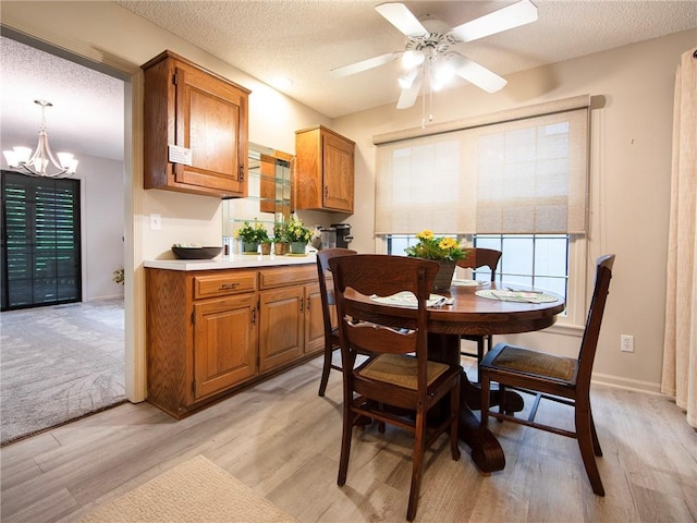 dining space featuring plenty of natural light, a textured ceiling, and light wood-type flooring