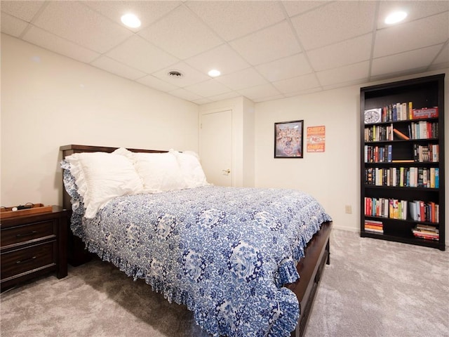 carpeted bedroom featuring a drop ceiling, recessed lighting, and visible vents