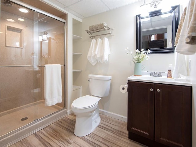 full bathroom with vanity, toilet, baseboards, wood finished floors, and a stall shower