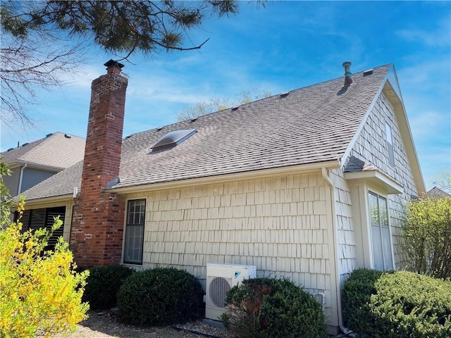 view of home's exterior featuring roof with shingles, ac unit, and a chimney