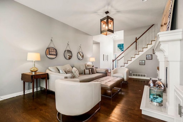 living area featuring dark wood-style floors, stairs, and baseboards