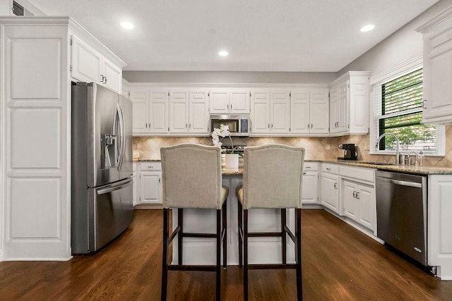 kitchen featuring appliances with stainless steel finishes, a sink, white cabinetry, and recessed lighting